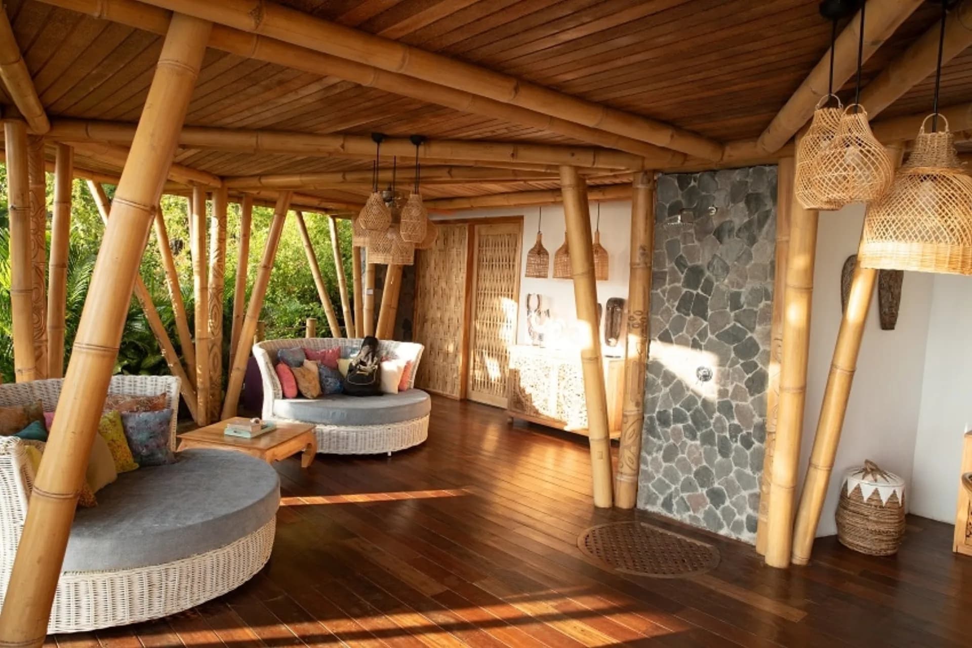 Bukit Lipah Resort covered pavilion with wooden beams, woven pendant lights, curved seating areas, and wooden flooring